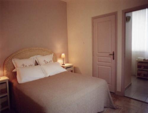 a bedroom with a white bed with two pillows at Chambres d'Hotes la Raspeliere in Cabourg