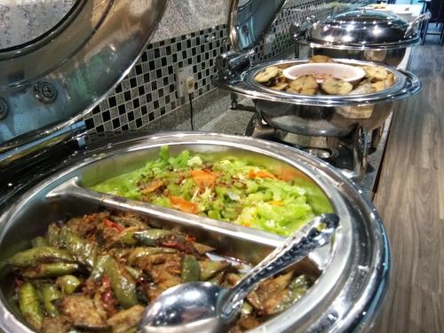a bunch of food in trays in a restaurant at Purnama Hotel in Limbang