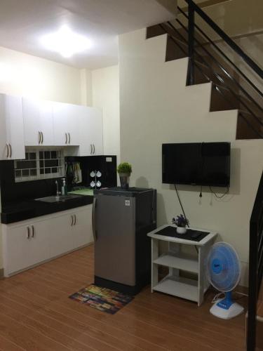 kuchnia z lodówką i telewizor w pokoju w obiekcie ESTILO APARTMENT 2-storey w mieście Loculan