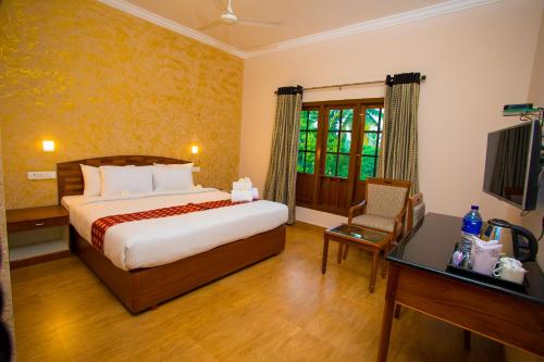 a bedroom with a bed and a desk and a television at Quality Airport Hotels in Nedumbassery