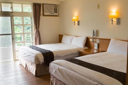 頭城的住宿－頭城休閒農場旅館，酒店客房设有两张床和窗户。