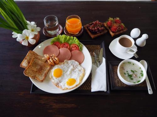 Un plato de desayuno con huevos, tostadas y café sobre una mesa. en BaanSuk Sukhothai Resort, en Sukhothai