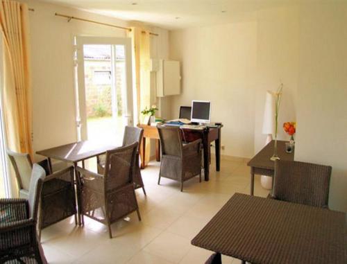 a dining room with a table and chairs and a desk at Chambres d'Hotes la Raspeliere in Cabourg