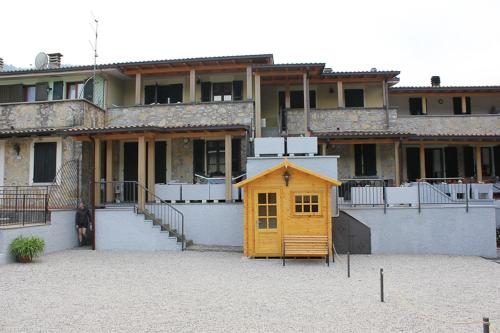 a small yellow house in front of a building at Residence Elettra in Crone