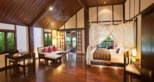 a bedroom with a bed and a living room at 3 Nagas Hotel Luang Prabang - MGallery Collection in Luang Prabang