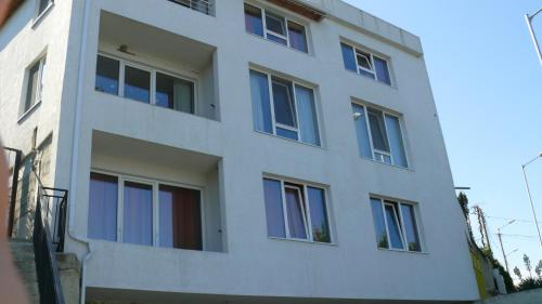 un edificio blanco con ventanas azules. en Villa Climate Guest House, en Varna