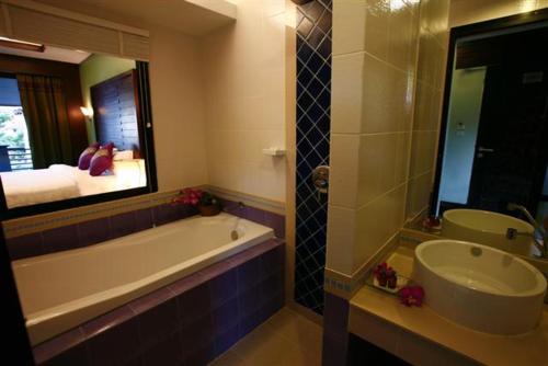 a bathroom with a tub and a sink and a mirror at Lamoon Lamai Residence & Guesthouse in Lamai
