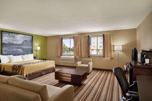 a hotel room with a bed and a couch at Super 8 by Wyndham S Jordan/Sandy/Slc Area in South Jordan