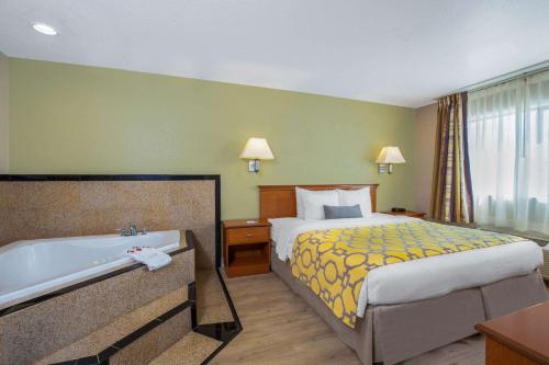 a hotel room with a bed and a bath tub at Baymont by Wyndham Tehachapi in Tehachapi
