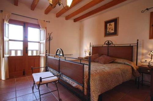a bedroom with a bed and a table and a window at Can Gat in Sant Carles de Peralta