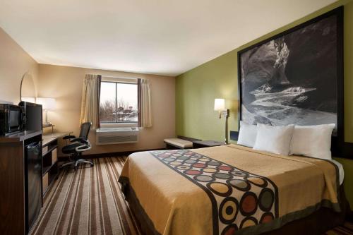 a hotel room with a bed and a television at Super 8 by Wyndham S Jordan/Sandy/Slc Area in South Jordan