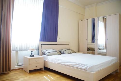 ein Schlafzimmer mit einem großen weißen Bett und einem Fenster in der Unterkunft Neftçilər prospekti . Bedrooms 2. in Baku