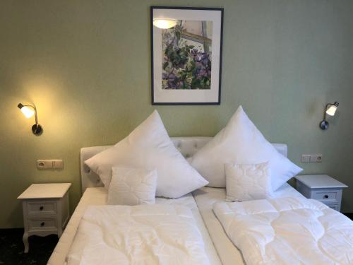 a bedroom with two beds with white sheets and pillows at Hotel Alpenrose gut schlafen & frühstücken in Scheidegg