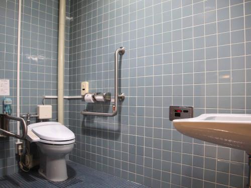 a blue tiled bathroom with a toilet and a sink at Hotel ab Shiga in Otsu