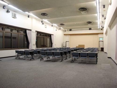 a room with rows of tables and chairs in it at Hotel ab Shiga in Otsu
