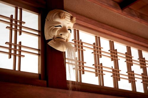 a mask on the wall of a window at Hotobil B&B 潤 An inn that enjoys breakfast in Nara