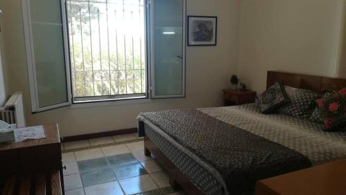 a bedroom with a bed and a window at Domaine de Chouchene in Şaḩrat al Qashsh