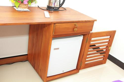 a wooden desk with a white dishwasher under a table at Maduranga n Guest in Mirissa