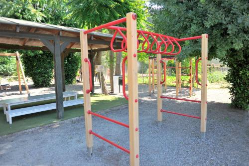 a playground with a red apparatus in a park at Olympic Palace Hotel in Ixia