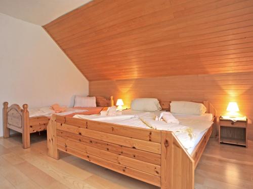 a bedroom with two beds and a wooden ceiling at Haus Göhringer / Ferienwohnungen in Hermagor