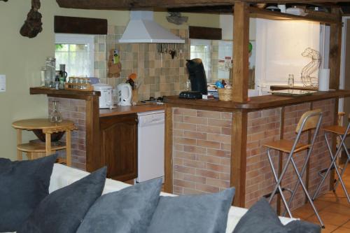 uma cozinha com uma parede de tijolos e uma cozinha com um balcão em Le p'tit hameau de Sey em Quettehou
