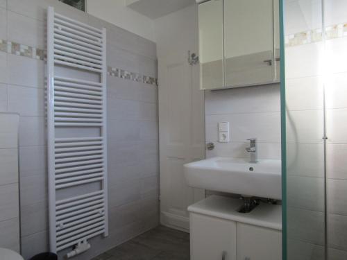 a white bathroom with a sink and a mirror at Historisches Fachwerkhaus in Reifferscheid