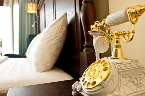 a golden phone sitting on a table next to a bed at Sunrise Garden House - Luang Prabang in Luang Prabang