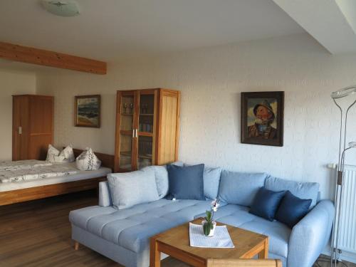 sala de estar con sofá azul y cama en Ferienhaus Kaptein Meyer, en Zingst