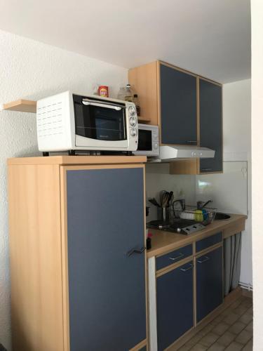 - un four micro-ondes installé au-dessus d'un meuble de cuisine dans l'établissement Maison de vacance Hourtin Lac, à Hourtin