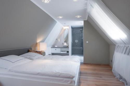a bedroom with a white bed and a staircase at Hotel Domschenke in Billerbeck