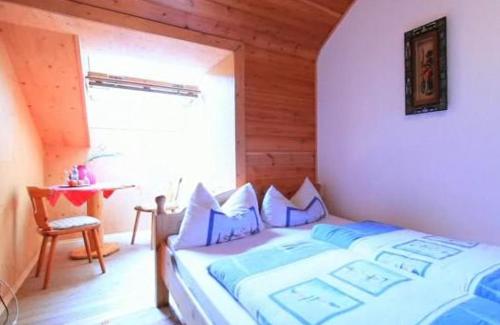 a bedroom with a bed and a table and a window at Landgasthaus Am Frauenstein in Hinterweidenthal