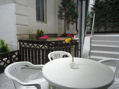 a white table and chairs with a vase on it at Hotel Adam in Berlin