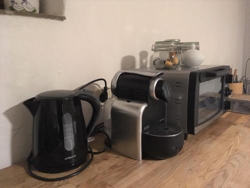 eine Kaffeemaschine und eine Kaffeemaschine neben einer Mikrowelle in der Unterkunft Am Ziegenhof in Parndorf