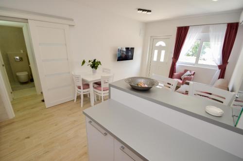 a kitchen and living room with a table and chairs at Seafront apartment Vujovic in Prčanj