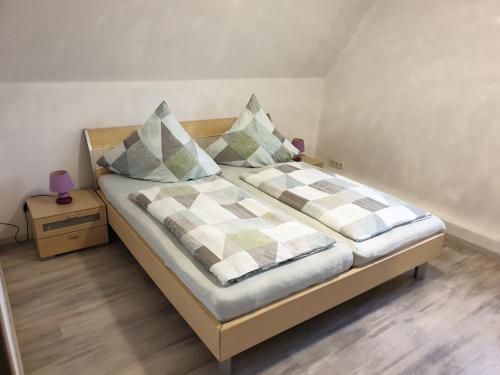 um quarto com uma cama com duas almofadas em Ferienwohnung Helena em Emden