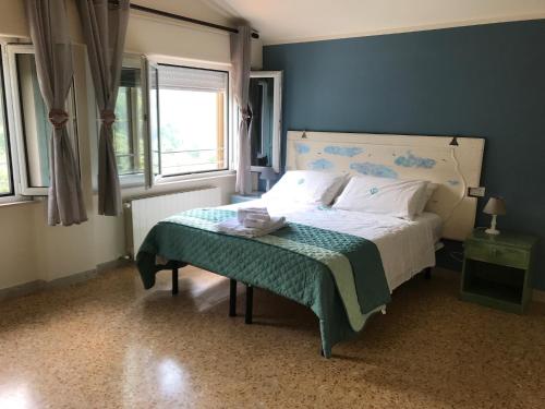 B&B La Casa di Alice في كامايوري: غرفة نوم بسرير مع جدار ازرق