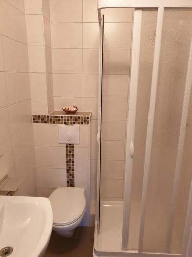 uma casa de banho com um WC, um lavatório e um chuveiro em Ferienwohnung Helena em Emden