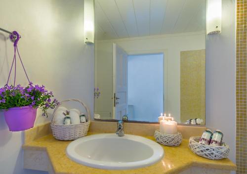 a bathroom sink with a candle and a mirror at Ornos Blue in Ornos