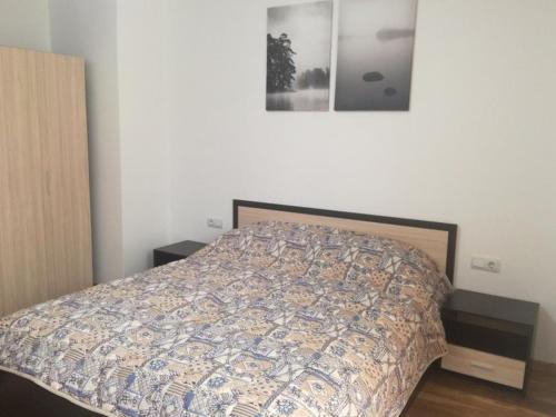 a bedroom with a bed with a comforter on it at Fashion Apartments in Sandanski