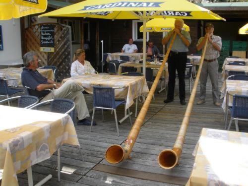 two baseball bats and an umbrella on a patio at Hotel Rhonequelle in Oberwald