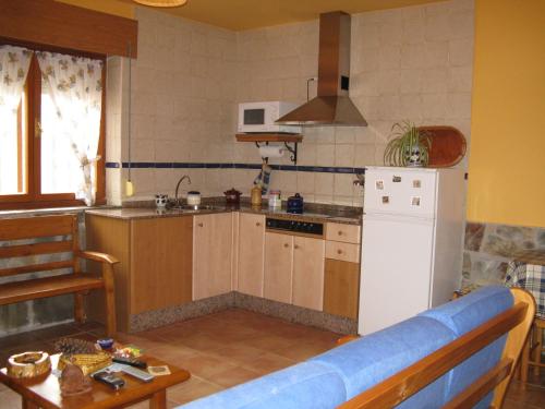 cocina con nevera blanca y mesa en Apartamentos Rurales Casa El Caminero, en Merás