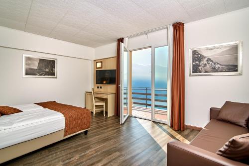 ein Hotelzimmer mit einem Bett und einem Balkon in der Unterkunft Hotel Le Balze - Aktiv & Wellness in Tremosine sul Garda