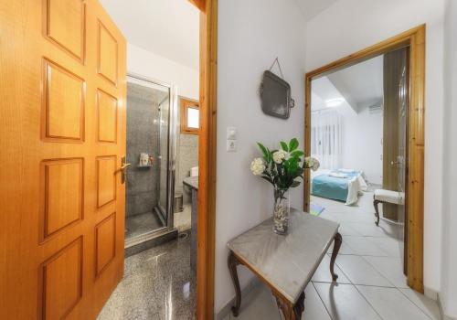 a vase of flowers on a table next to a door at Villa Eleni - Maisonette with Ocean panorama terrace in Alikanas