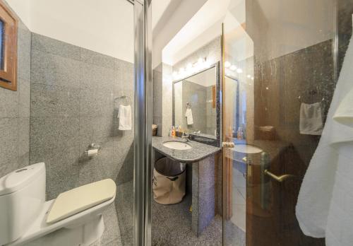 a bathroom with a sink and a toilet and a mirror at Villa Eleni - Maisonette with Ocean panorama terrace in Alikanas