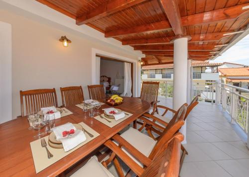 a dining room with a wooden table and chairs at Villa Eleni - Maisonette with Ocean panorama terrace in Alikanas