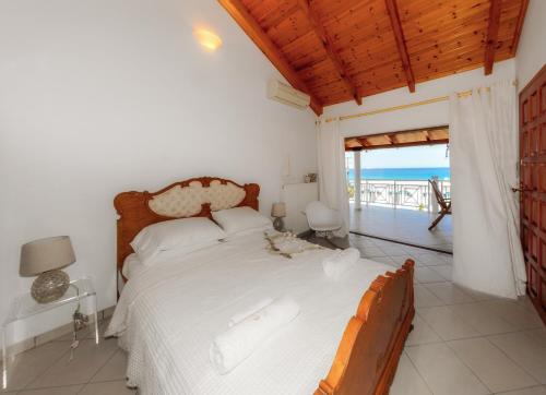 a bedroom with a bed and a view of the ocean at Villa Eleni - Maisonette with Ocean panorama terrace in Alikanas