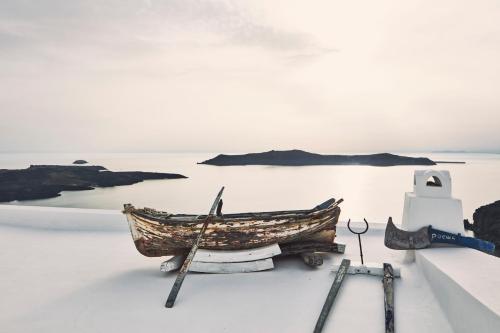 a boat and two oars sitting on the snow at Homeric Poems in Fira