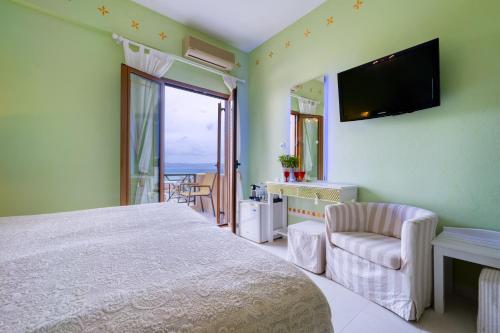 a bedroom with a bed and a tv and a chair at Rozmari and Spa in Agia Galini