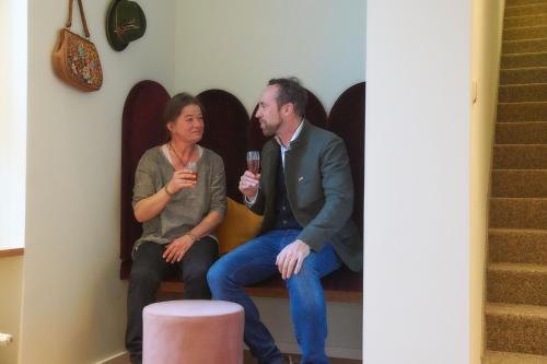 a man and a woman sitting on stairs holding wine glasses at Rosi Boutique Hotel in Regensburg