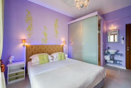 a purple bedroom with a large bed and a sink at Rozmari and Spa in Agia Galini